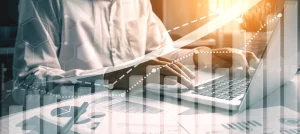 closeup of man working at laptop with data trend graphic overlays