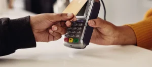 closeup of male hand holding credit card up to card reader