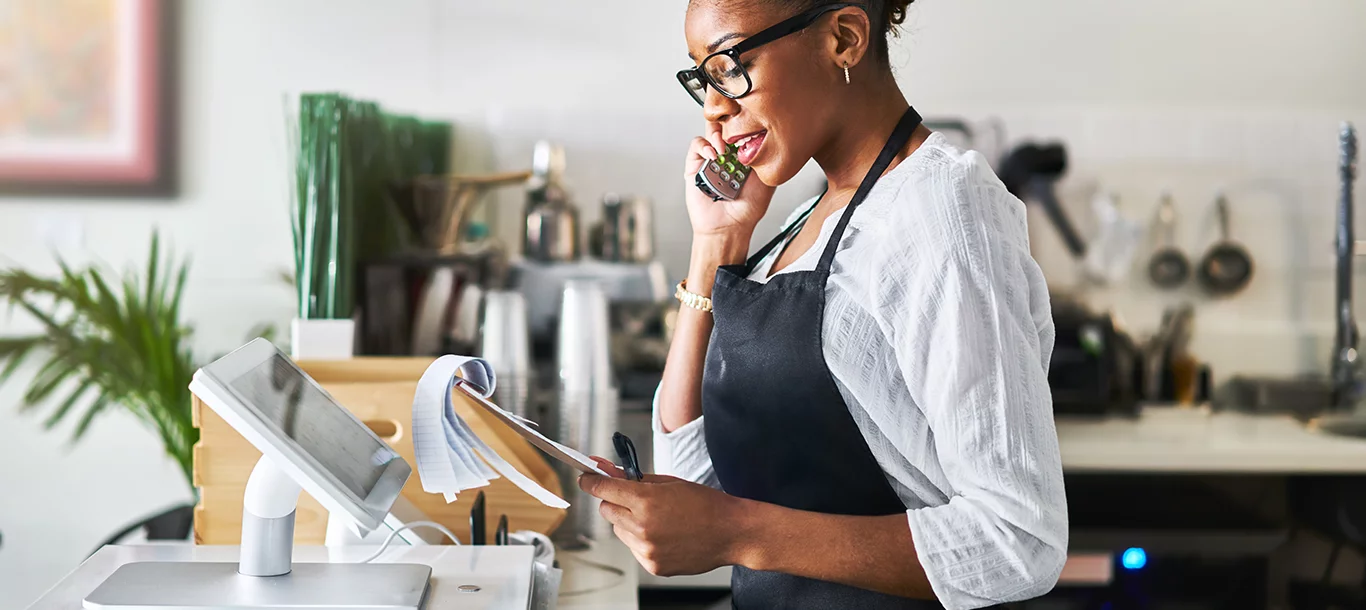 Business owner going over notes with client over the phone