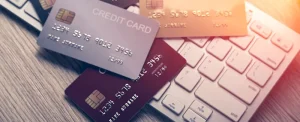 credit cards lying on computer keyboard with sunlight filtering across