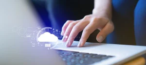 closeup of female hand on laptop trackpad with white cloud graphic overlay