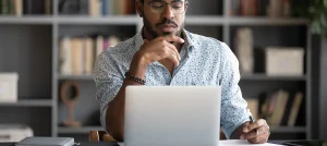 young black man working in front of laptop