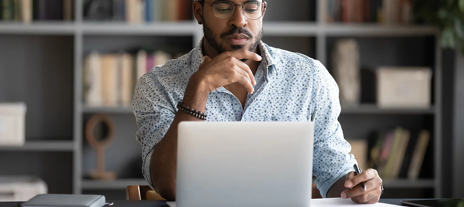 Young professional working with laptop open on their desk