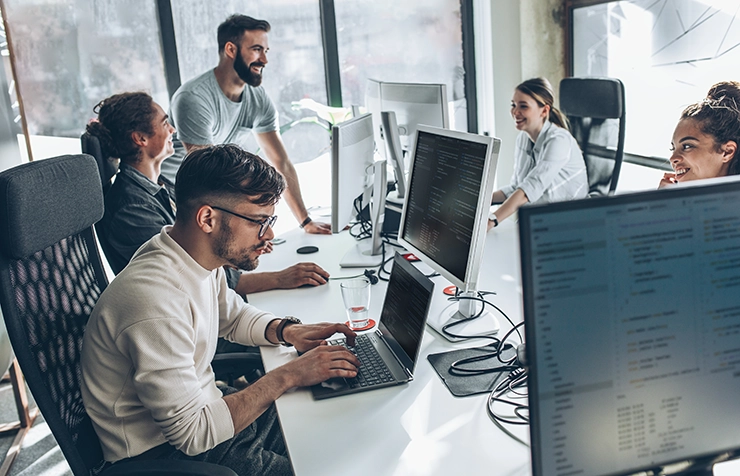 Team smiling and working in bright office