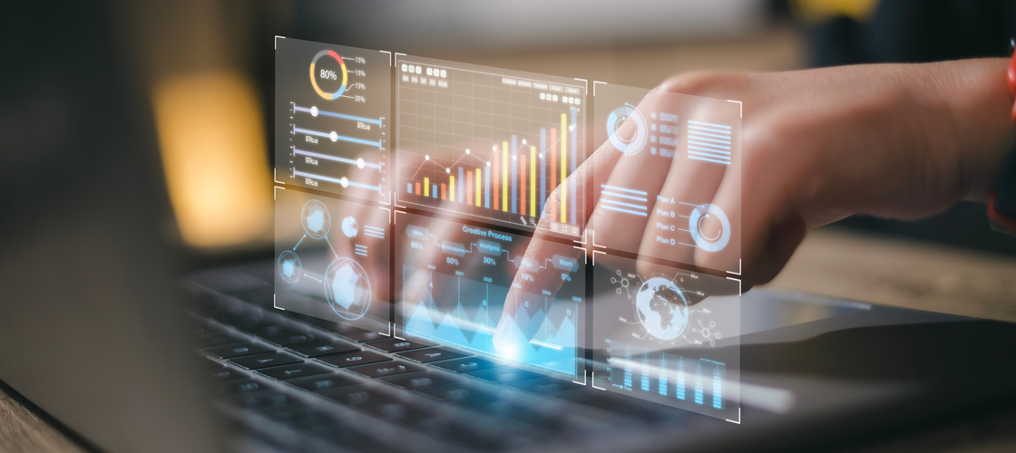 Hands typing on laptop while holographic analytics appear